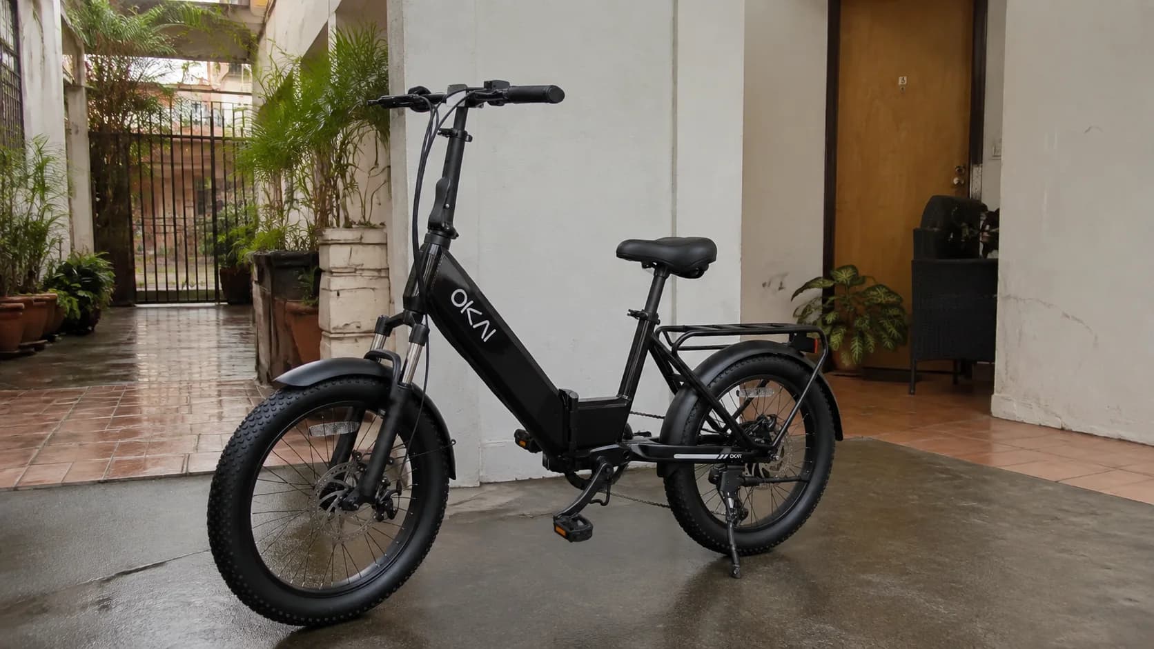 OKAI Flexmov folding electric bike stored at an apartment